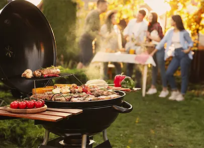 People in a garden enjoying food on a barbeque