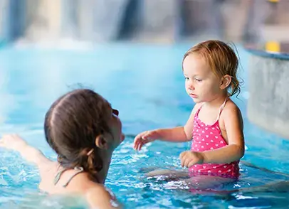 طفل وشخص بالغ برفقة بعضهما في حمام السباحة